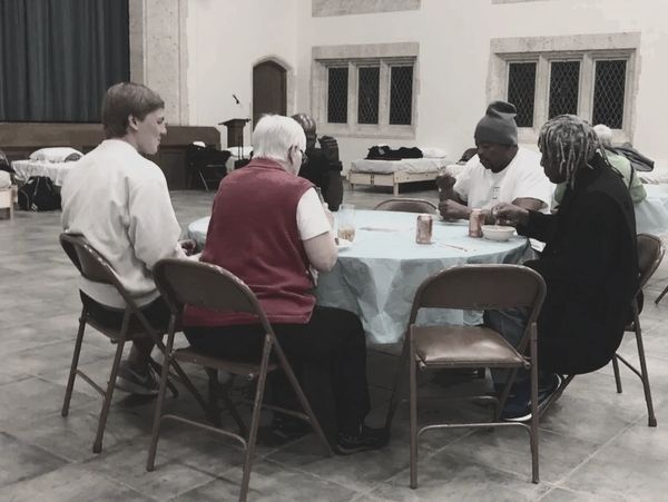 Room in the inn guests and volunteers have dinner.
